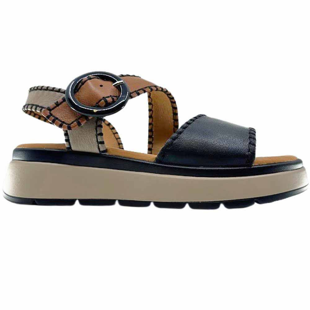 A sandal with black, taupe and tan leather straps with stitched edged detailing and a round buckle, set on a beige platform sole, against a white background.