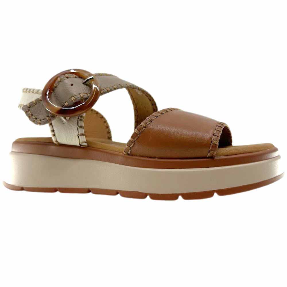 A sandal with tan, taupe and cream leather straps with stitched edged detailing and a round buckle, set on a beige platform sole, against a white background.