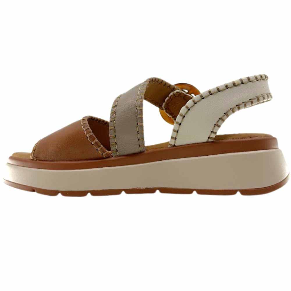 A sandal with tan, taupe and cream leather straps with stitched edged detailing and a round buckle, set on a beige platform sole, against a white background.