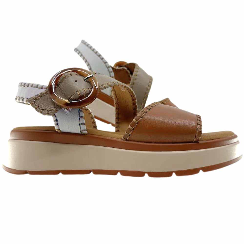 A pair of sandals with tan, taupe and cream leather straps with stitched edged detailing and a round buckle, set on a beige platform sole, against a white background.
