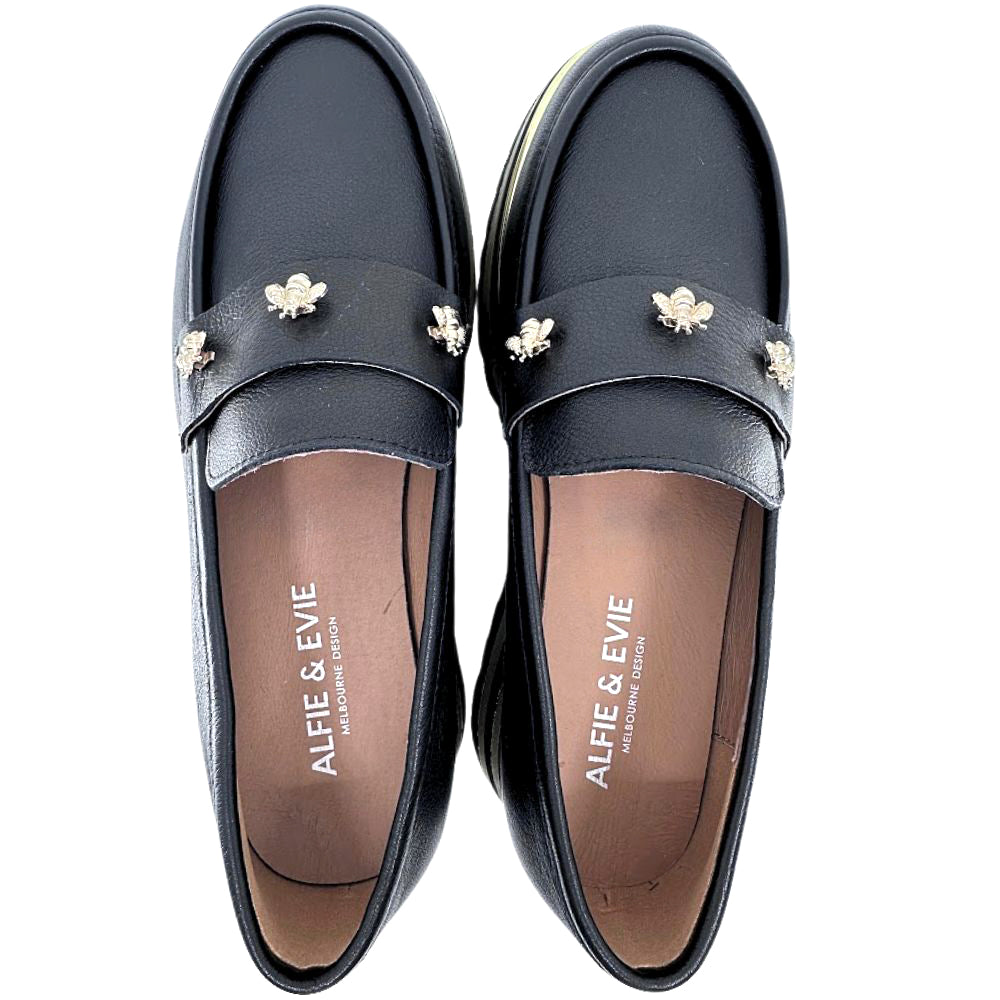 Pair of black loafers with decorative bee elements on a white background