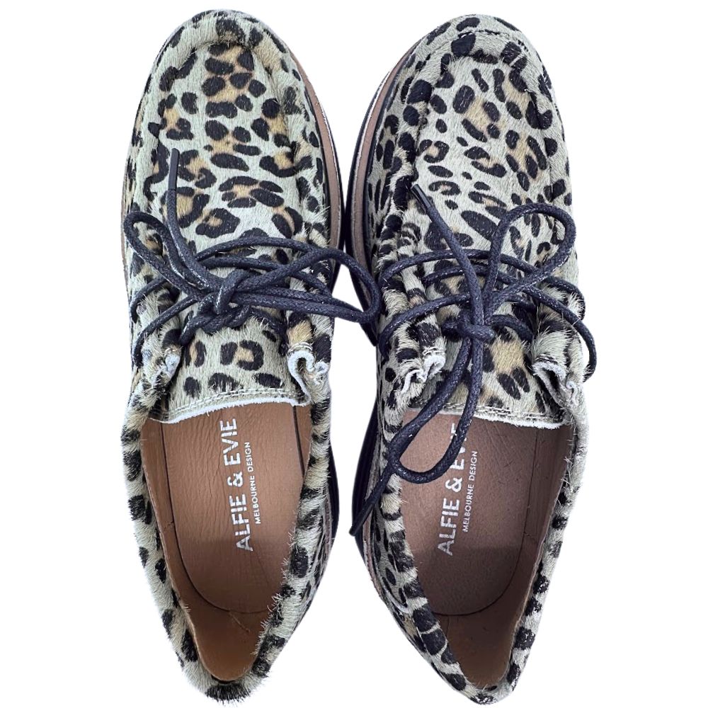 Pair of leopard print shoes with black laces on a white background