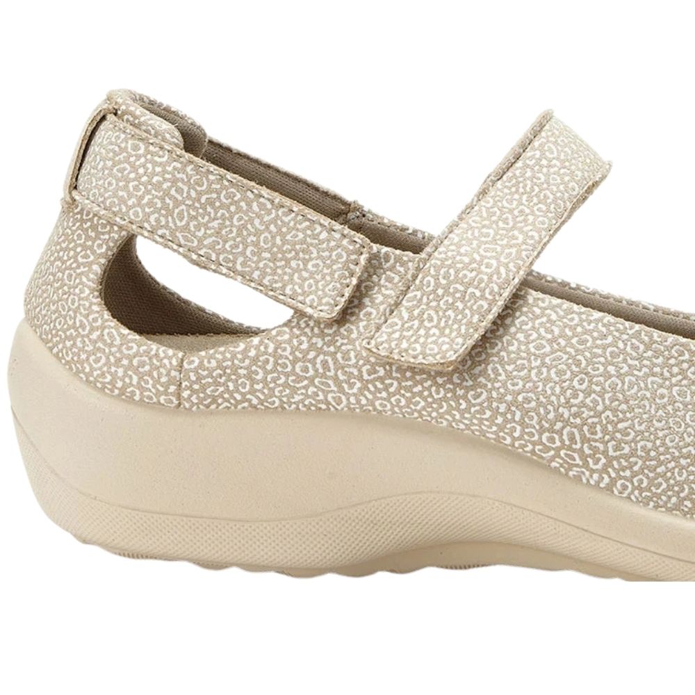 A close-up side view of a beige slip-on shoe with a textured leopard print pattern and a thick cushioned sole, set against a plain white background.