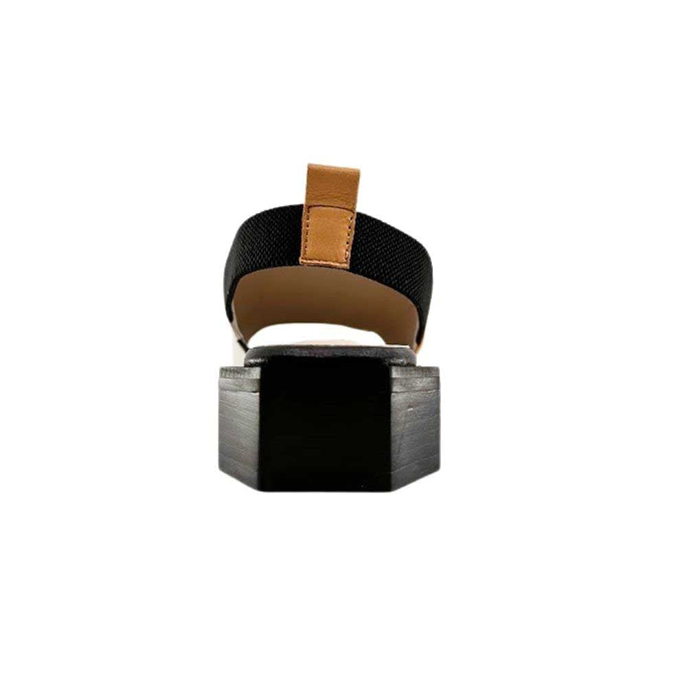 The back of a slide sandal showing a black uniquely shaped heel with a tan pull tab on an elastic back strap, against a white background