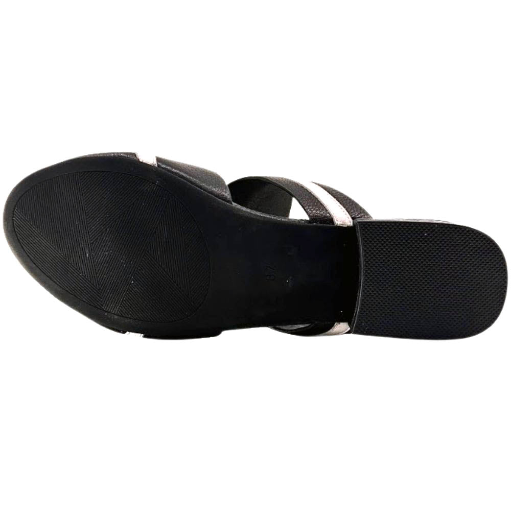 A black rubber sole of a sandal with a tread pattern on a white background