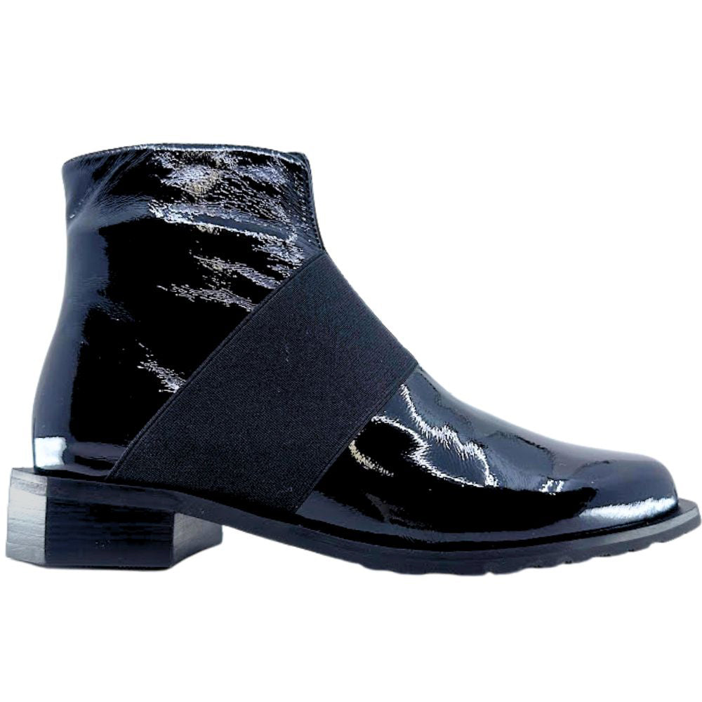 Black patent leather ankle boot with an elastic strap on a white background