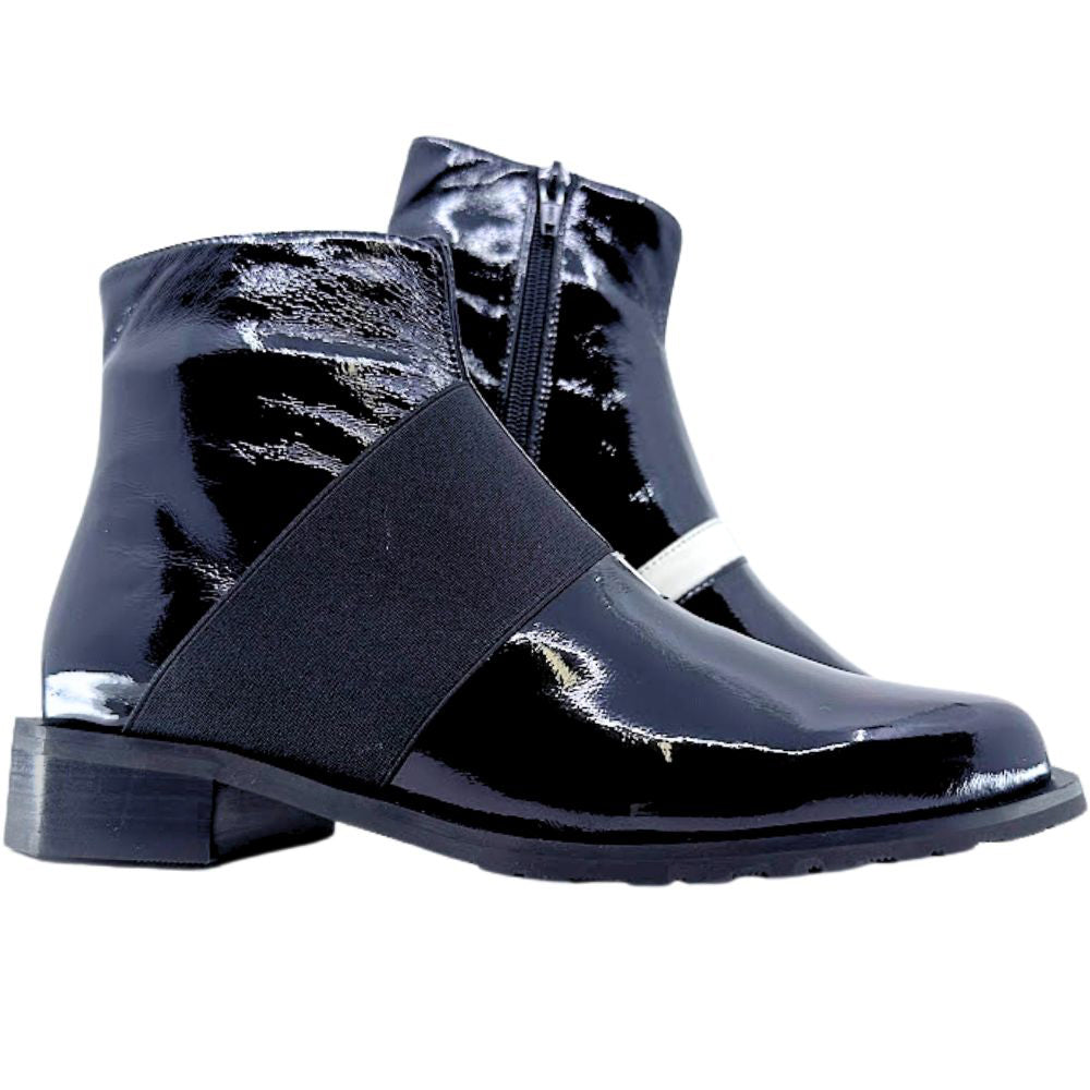 Black patent leather ankle boots with a black elastic strap on a white background