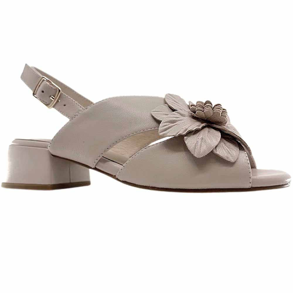 A single nude leather sandal with a floral leather embellishment across the vamp, peep toe and a low block heel, against a white background.