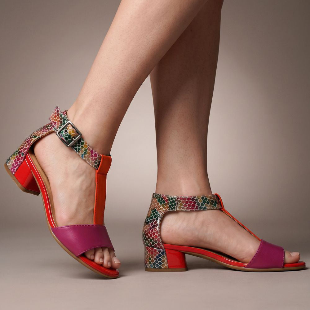 Person wearing colorful sandals with a patterned strap on a neutral background