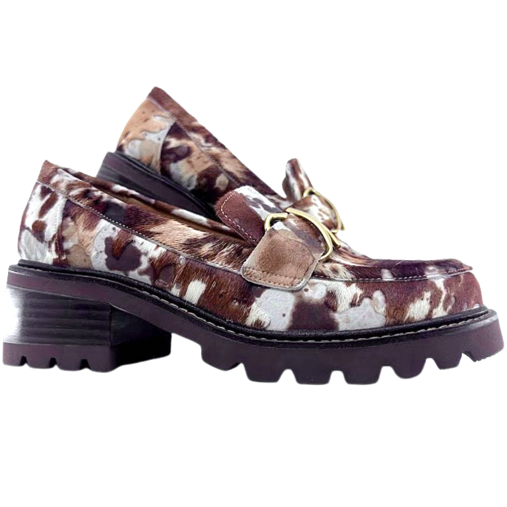 Pair of animal print brown and white loafer shoes with a gold buckle on a white background
