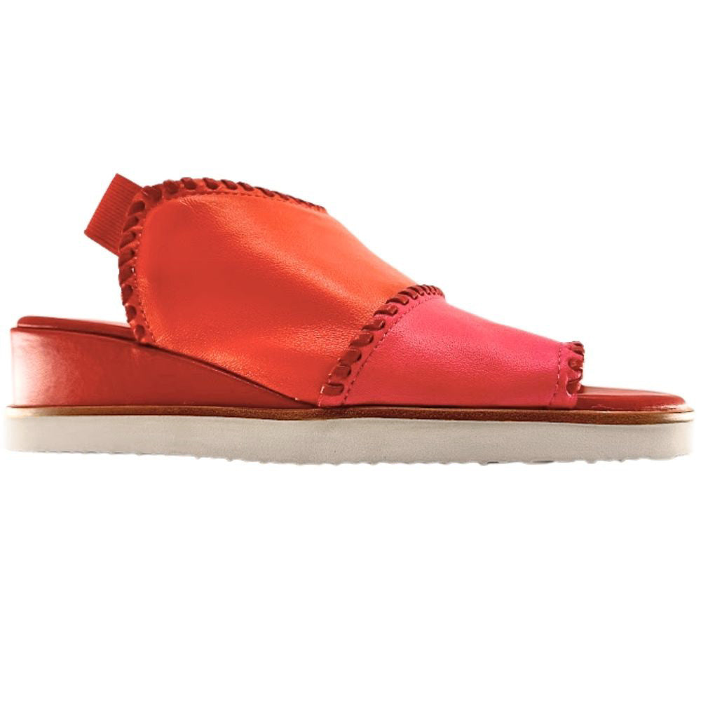A woman's wedge sandal in vibrant shades of coral orange, hot pink, and red, with braided trim and a white outsole, shown against a white background.