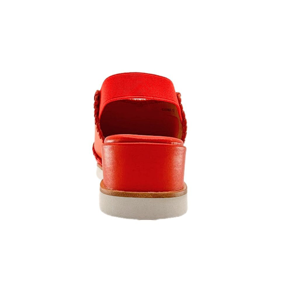 The back view of a woman's leather wedge sandal in a vibrant orange-red tone, showing an elastic rear back strap and a wedge sole on a white background.