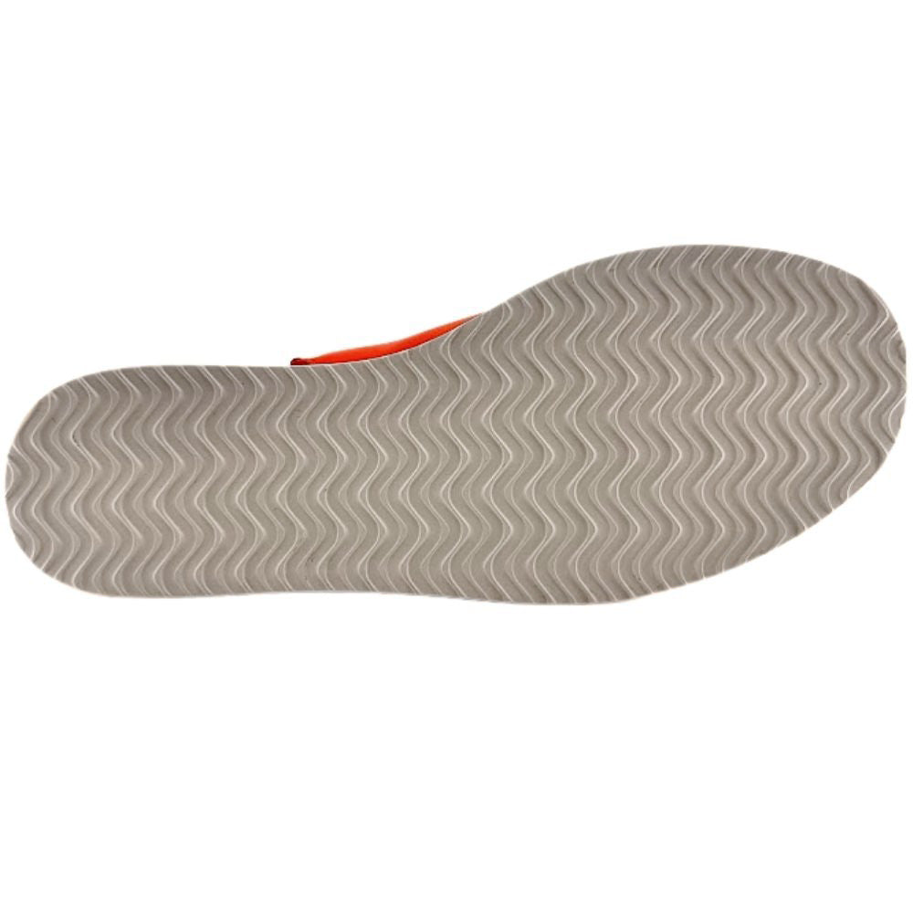 The outsole of a woman's wedge sandal, featuring a wavy chevron tread pattern in off-white, against a white background.