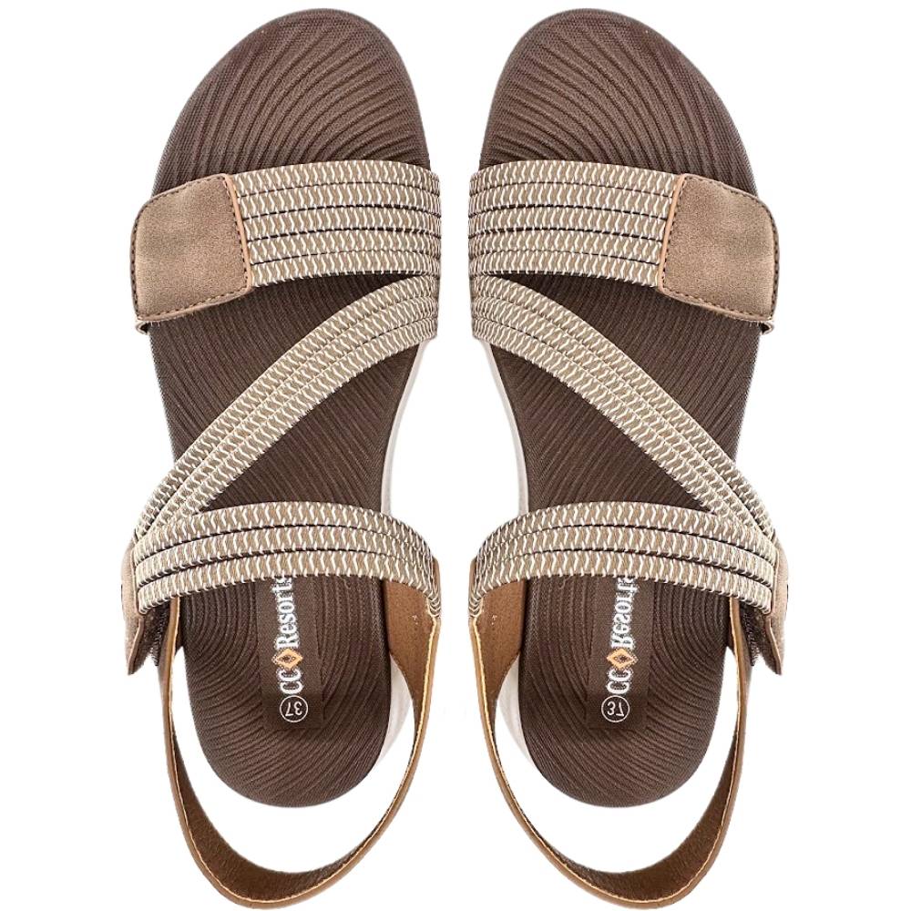 A pair of women's flat sandals with a dark brown ribbed footbed, dark brown and white woven elastic straps, and a dark brown leather accent on the side, shown from a top-down view on a white background. The brand name is 'CC Resorts'.