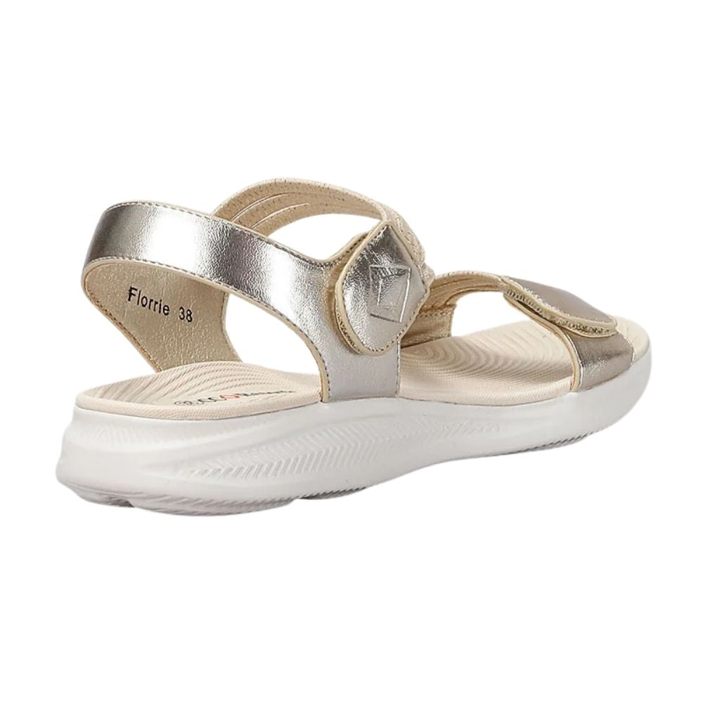 A metallic pale gold champagne and beige strappy sandal with a thick white sole, shown from a side profile view on a white background.