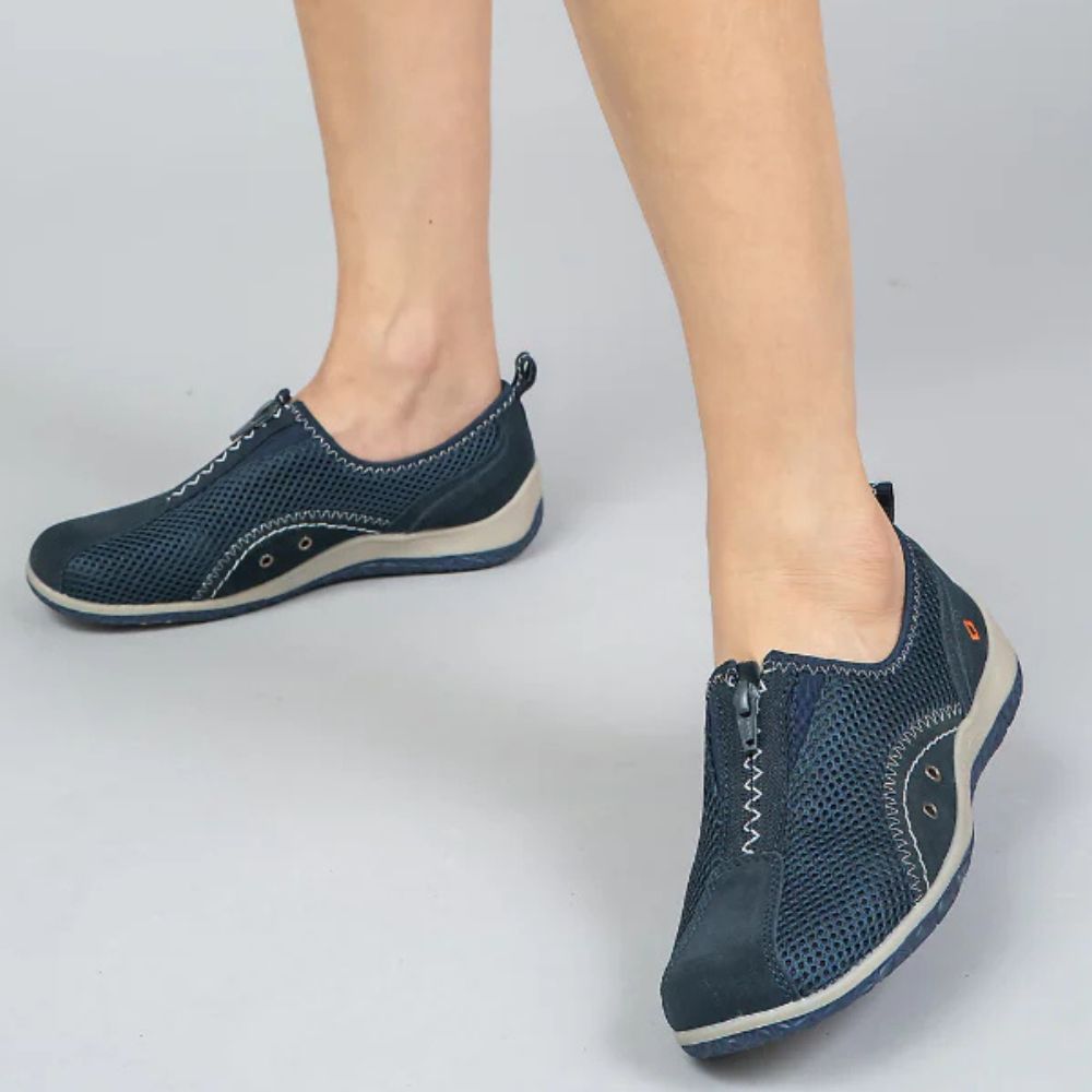 Navy blue casual shoes worn by a person on a light gray background