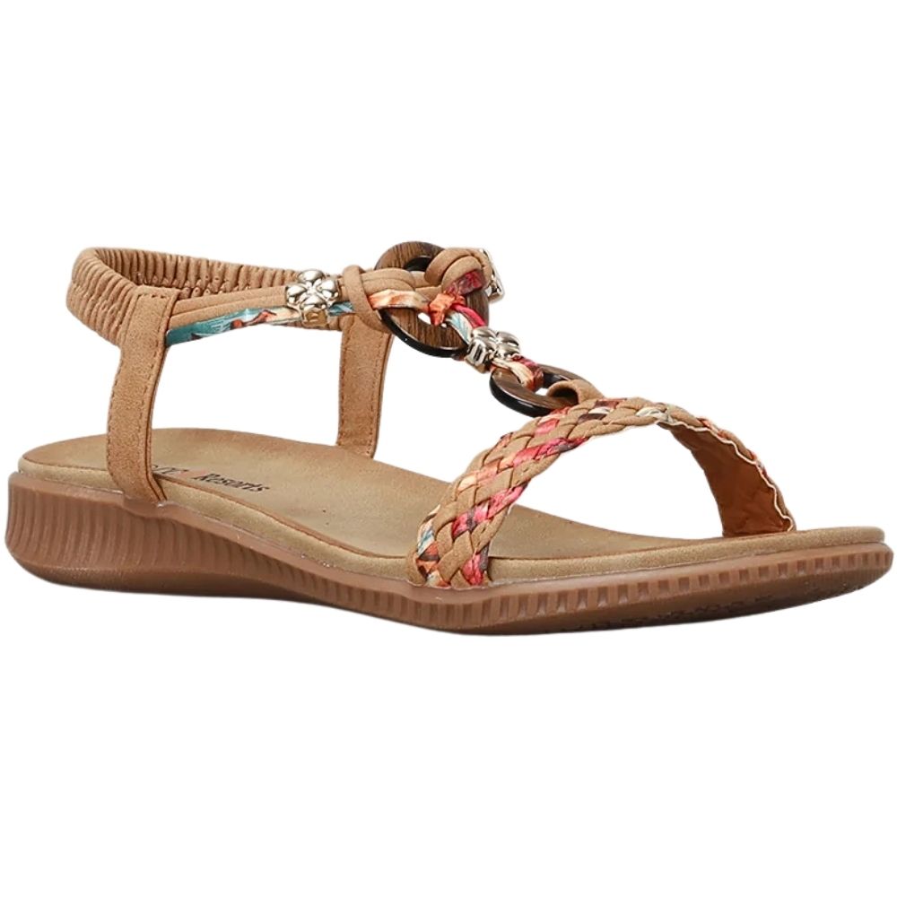 A tan wedge sandal with braided straps featuring a multicolor pattern, a decorative chain with wooden links and metal charms, and an adjustable ankle strap, shown on a plain white background.