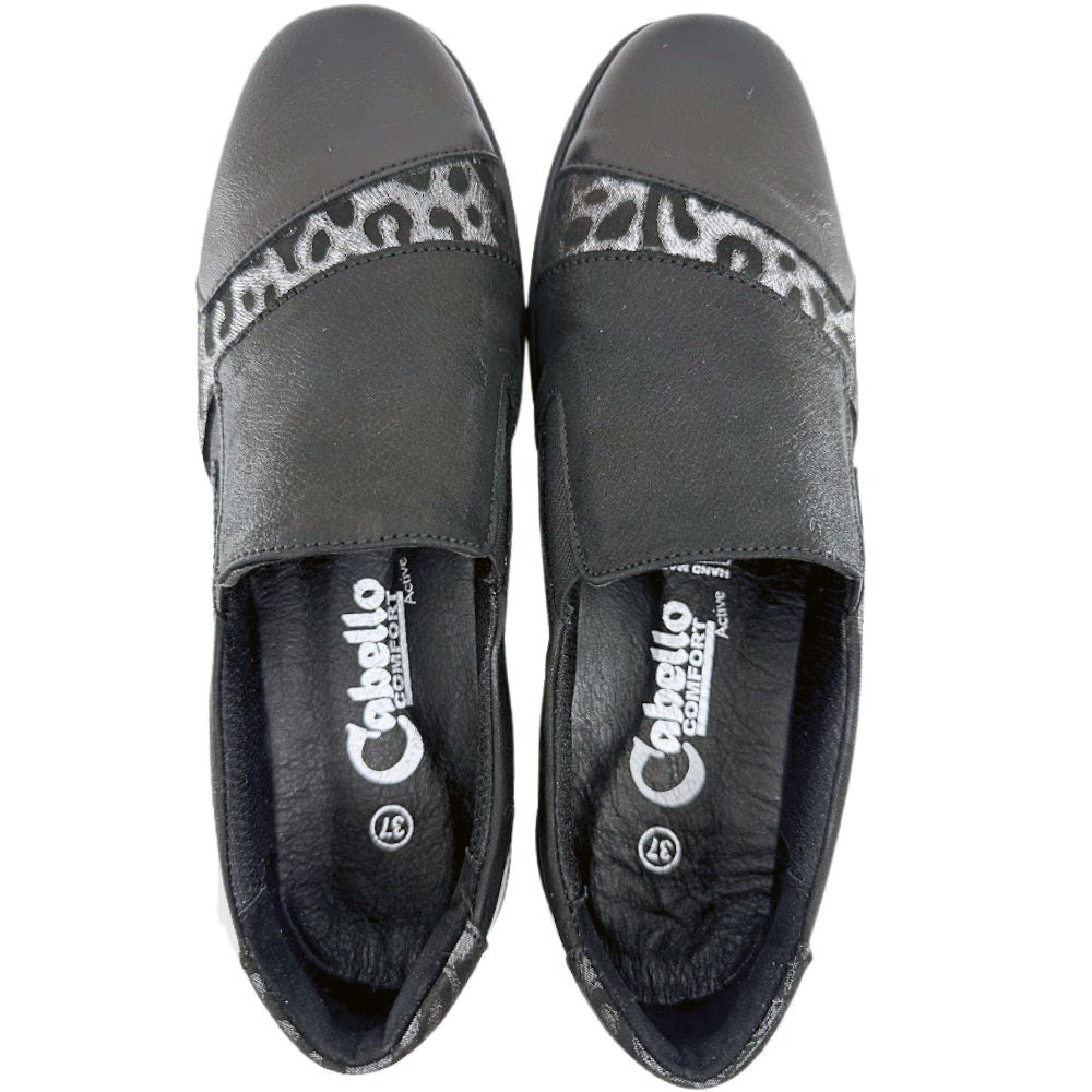 Pair of black slip-on shoes with leopard print detail on a white background