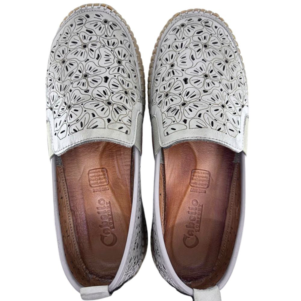 Taupe slip-on loafer shoes with floral laser-cut design on a white background