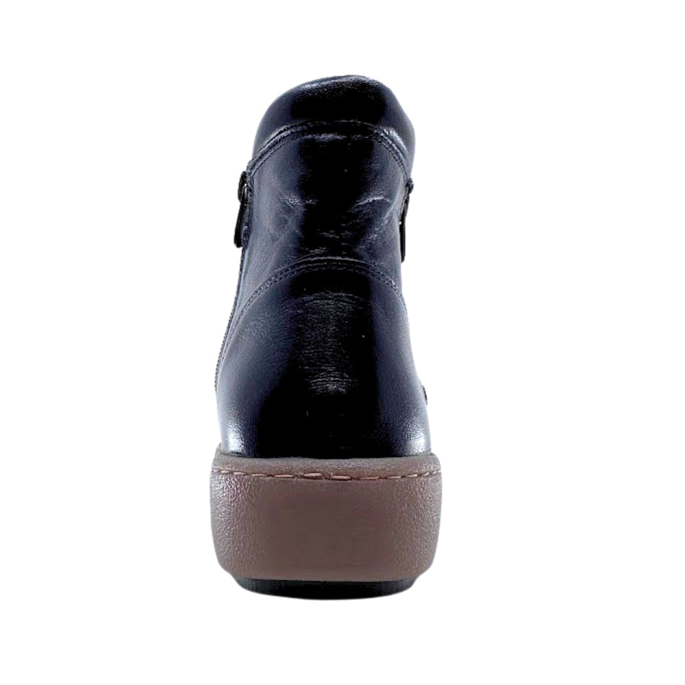 Black leather shoe with brown sole on a white background