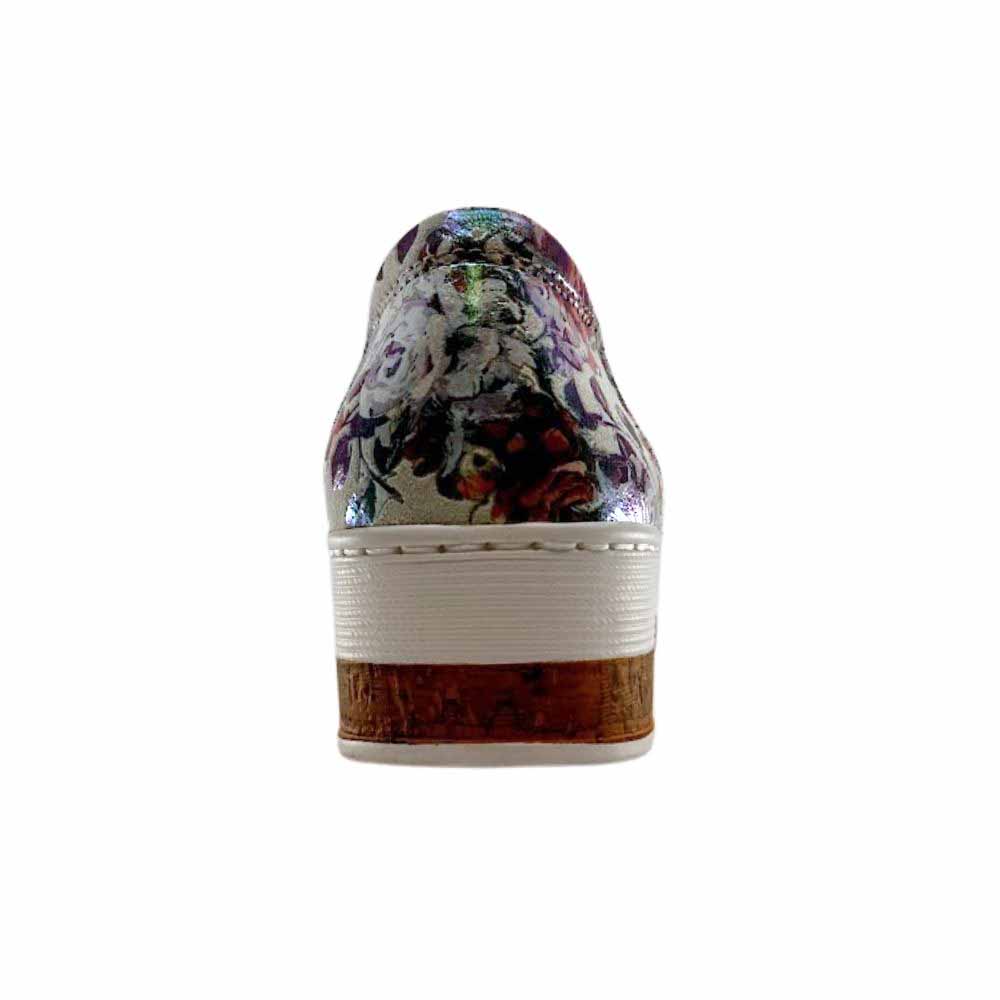 The back view of a women's slip-on wedge shoe featuring a metallic multicolor floral-patterned upper, a cork-look midsole, and a white stitched edge.