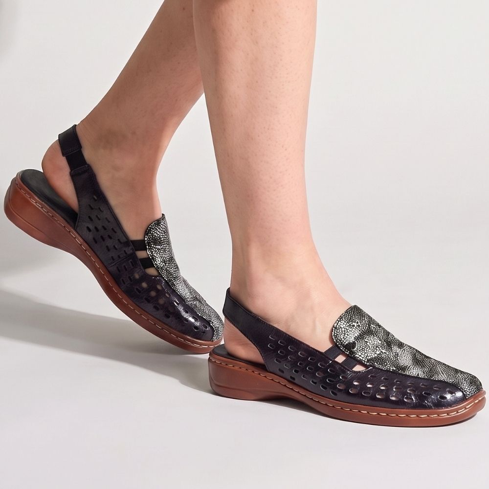 Navy perforated leather slingback sandal with a multicolour upper and a brown low wedge outsole, worn by a model against a studio background.