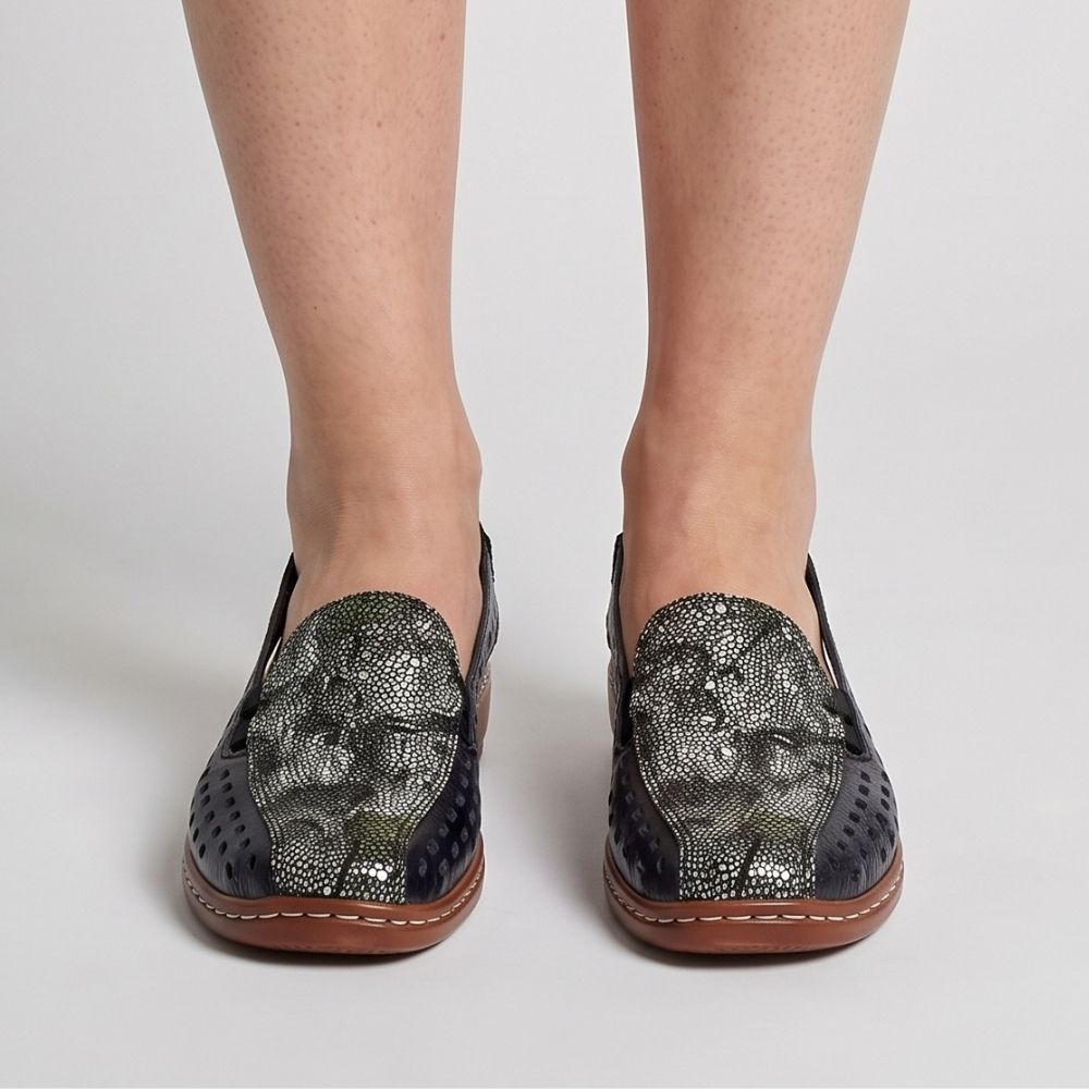 A model wearing a pair of women's slingback loafer sandals with a navy perforated leather upper, a multicolour toe cap, and a brown sole, shown from a front view against a studio background.