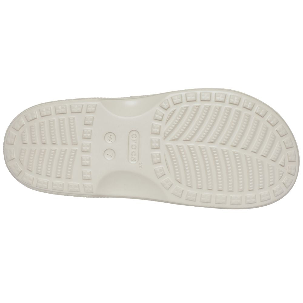 The white rubber outsole of a Crocs sandal, showing the brand name 'CROCS' molded into the center, photographed on a solid white background.