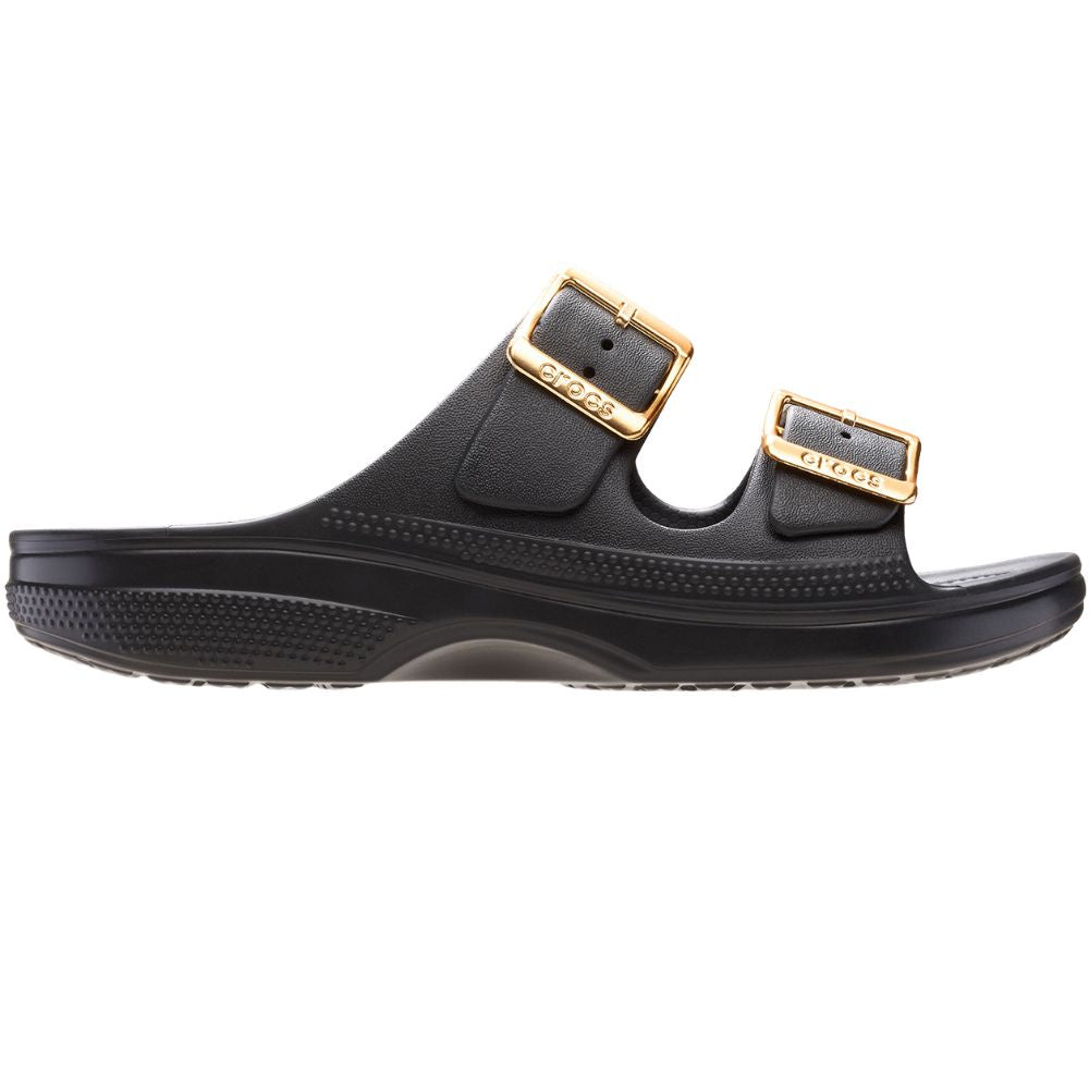 A black double-strap slide sandal with gold-tone buckle details, shown in a side profile view against a plain white background.