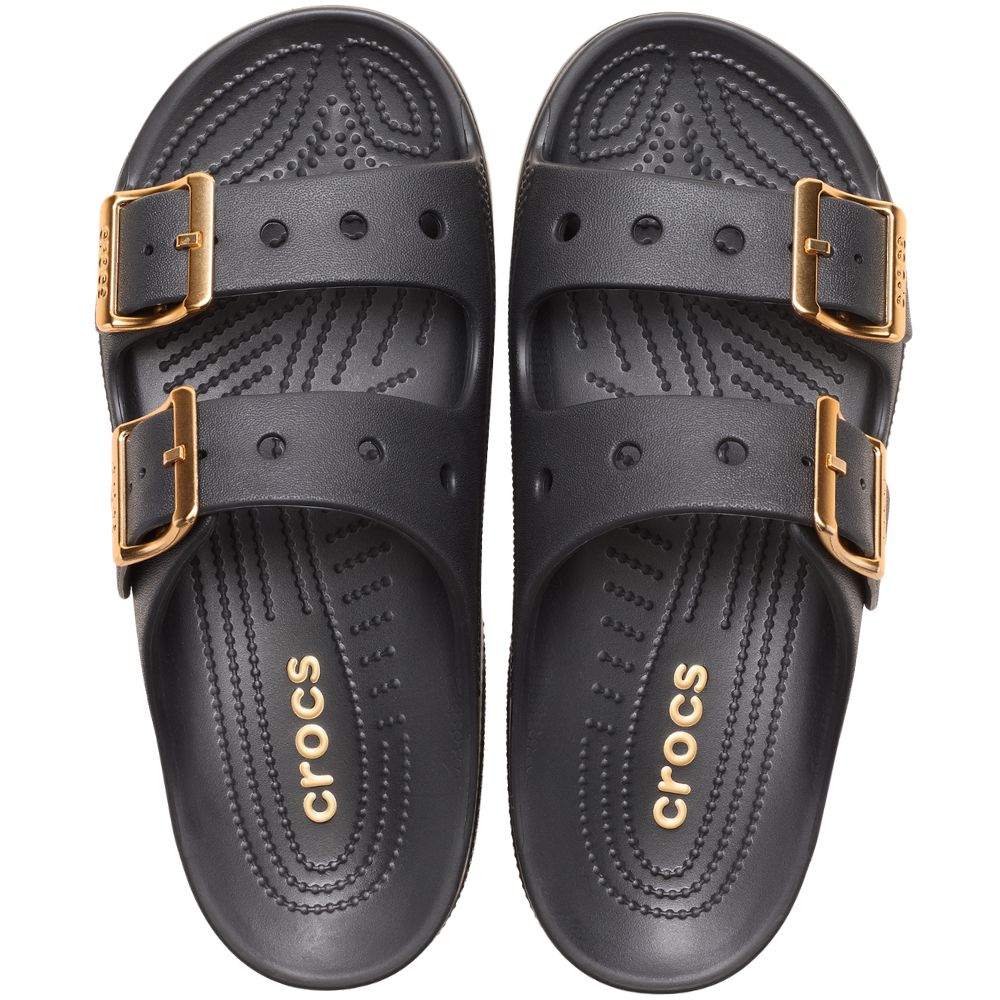 A pair of black Crocs double-strap slide sandals with gold-tone buckle details, shown from a top-down view on a white background.