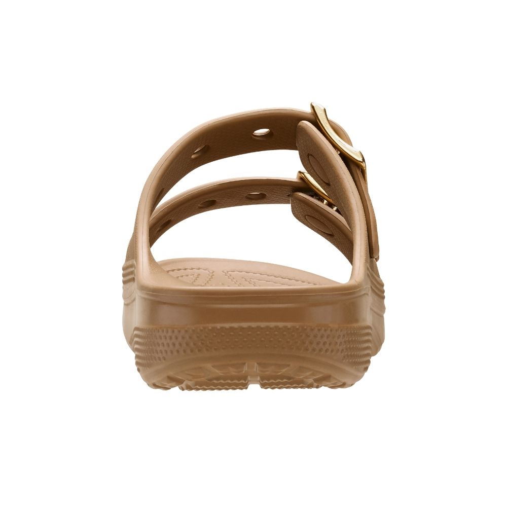 A single tan 'Crocs' sandal shown from the back, featuring a double strap design with gold-tone buckles and a textured sole, set against a plain white background.