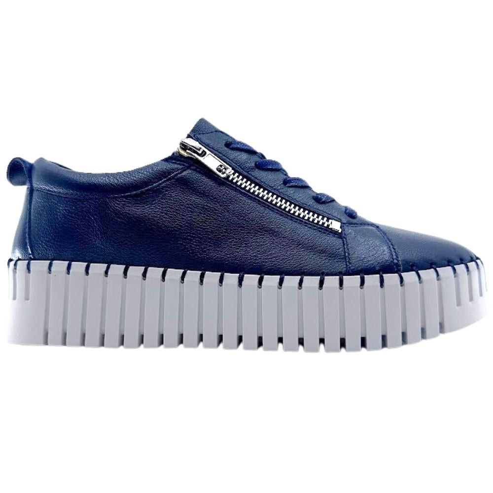 Navy sneaker with a white sole on a white background