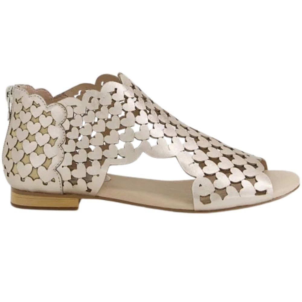A single flat sandal with a metallic champagne-gold upper featuring a heart-shaped cutout pattern and a scalloped edge, shown from a side profile on a white background.