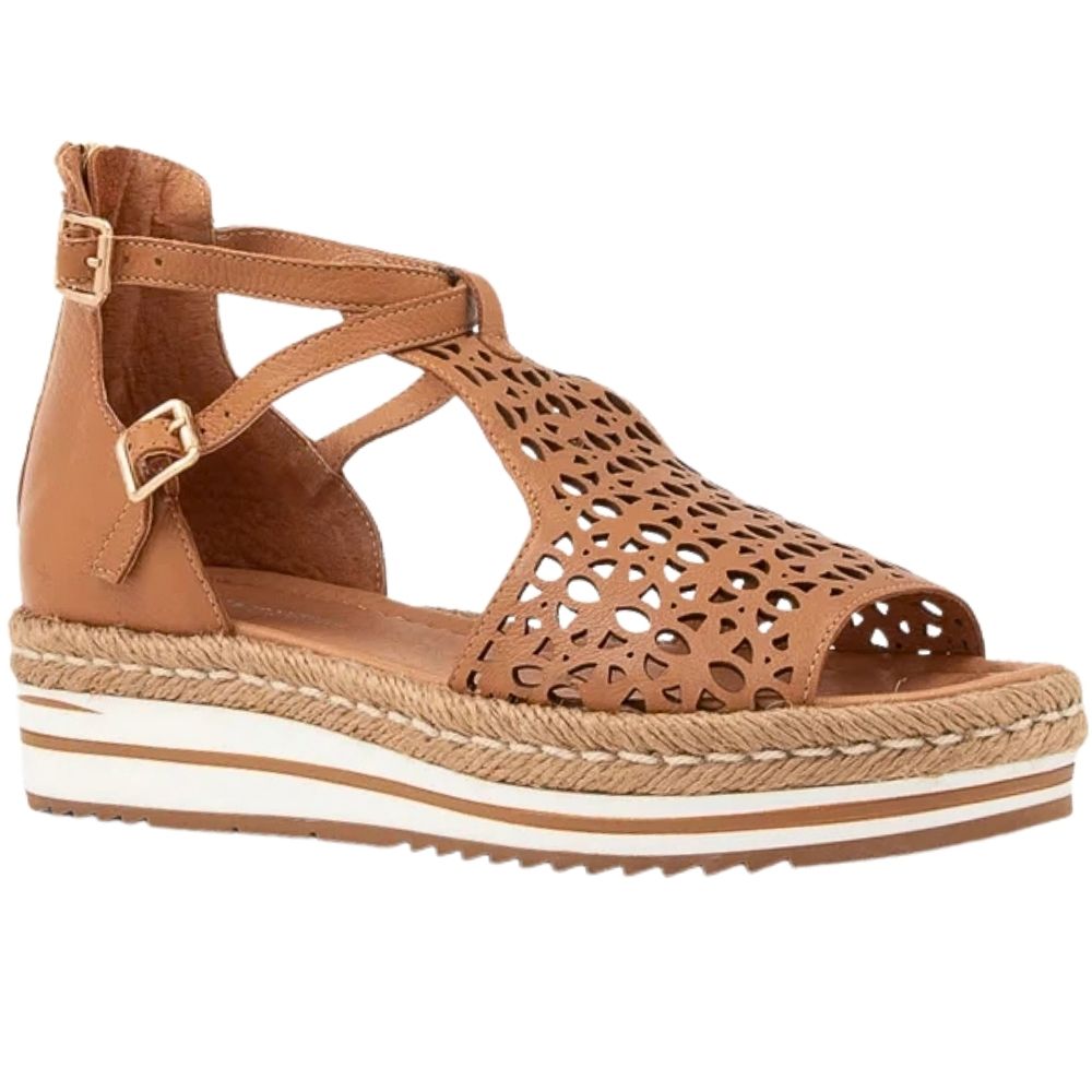 A tan leather wedge sandal with laser-cut geometric patterns on the toe and upper straps, featuring adjustable ankle straps with a gold-tone buckles, a braided jute-wrapped wedge platform, and a white midsole stripe.