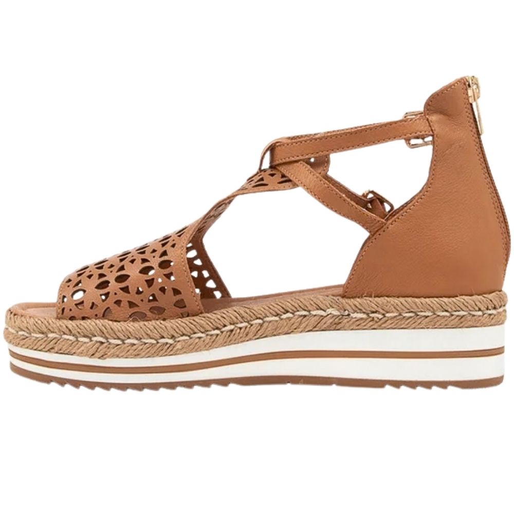 A tan leather wedge sandal with laser-cut geometric patterns on the toe and upper straps, featuring adjustable ankle straps with a gold-tone buckles, a braided jute-wrapped wedge platform, and a white midsole stripe.