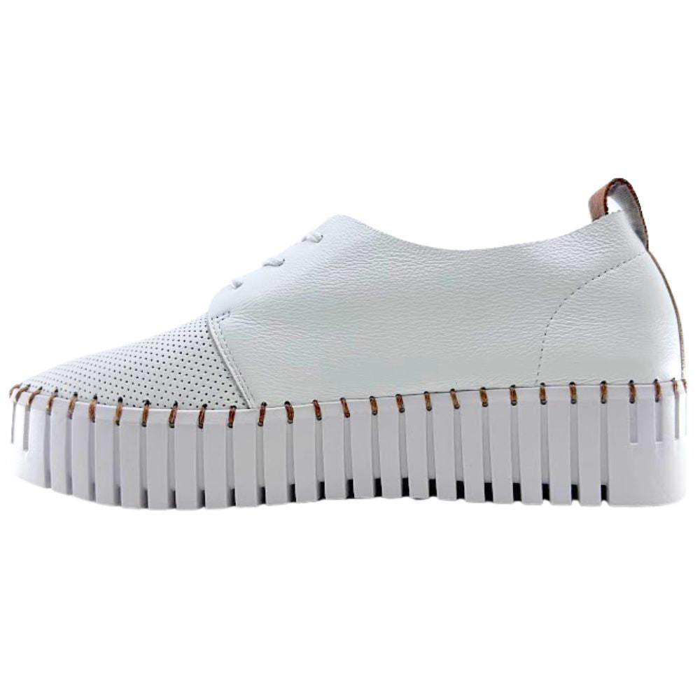 White sneaker with tan accents and a cleated sole on a white background