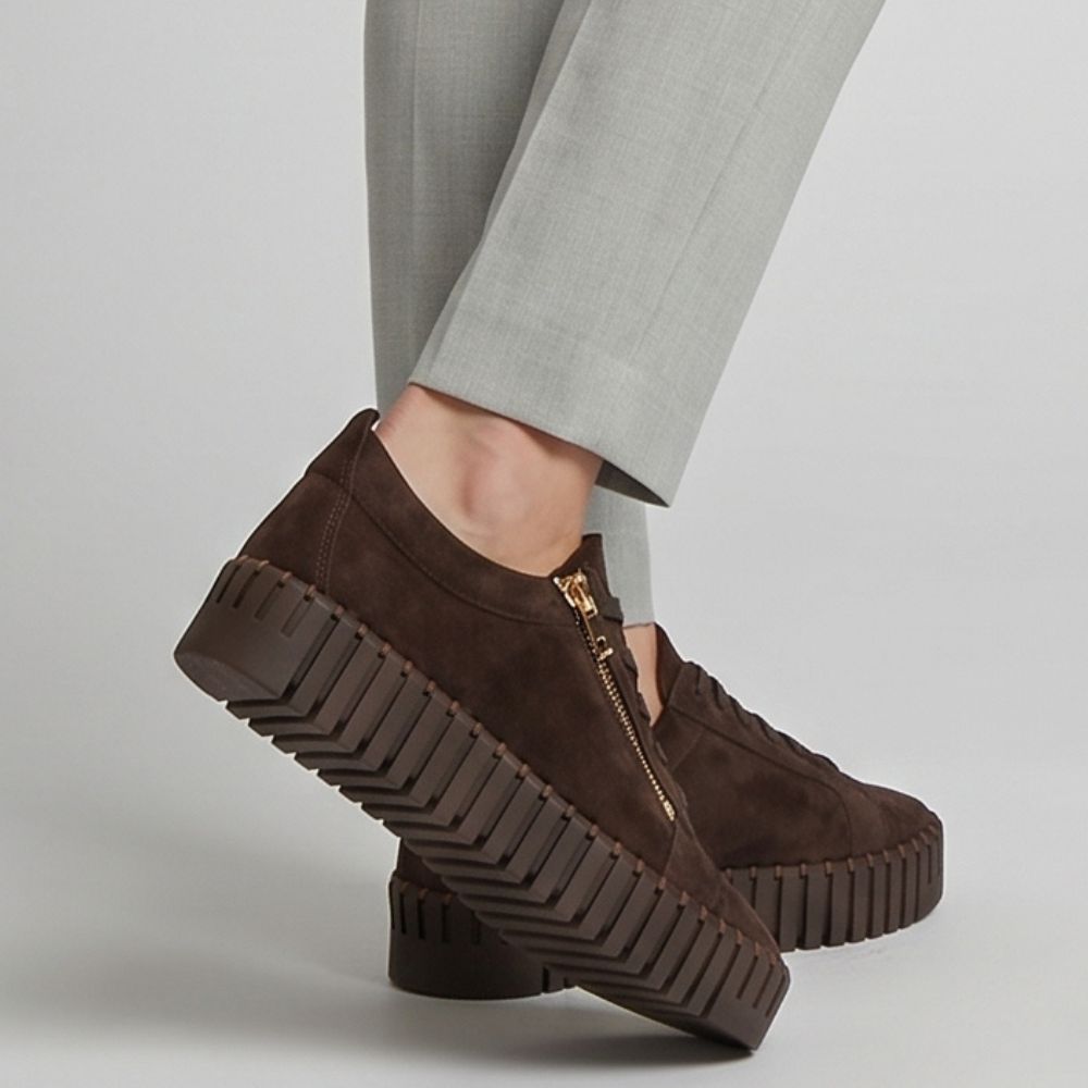 Brown suede platform sneakers with a gold zipper on a light gray background