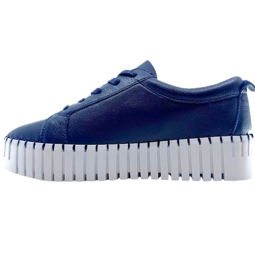 Navy sneaker with a thick white sole on a white background