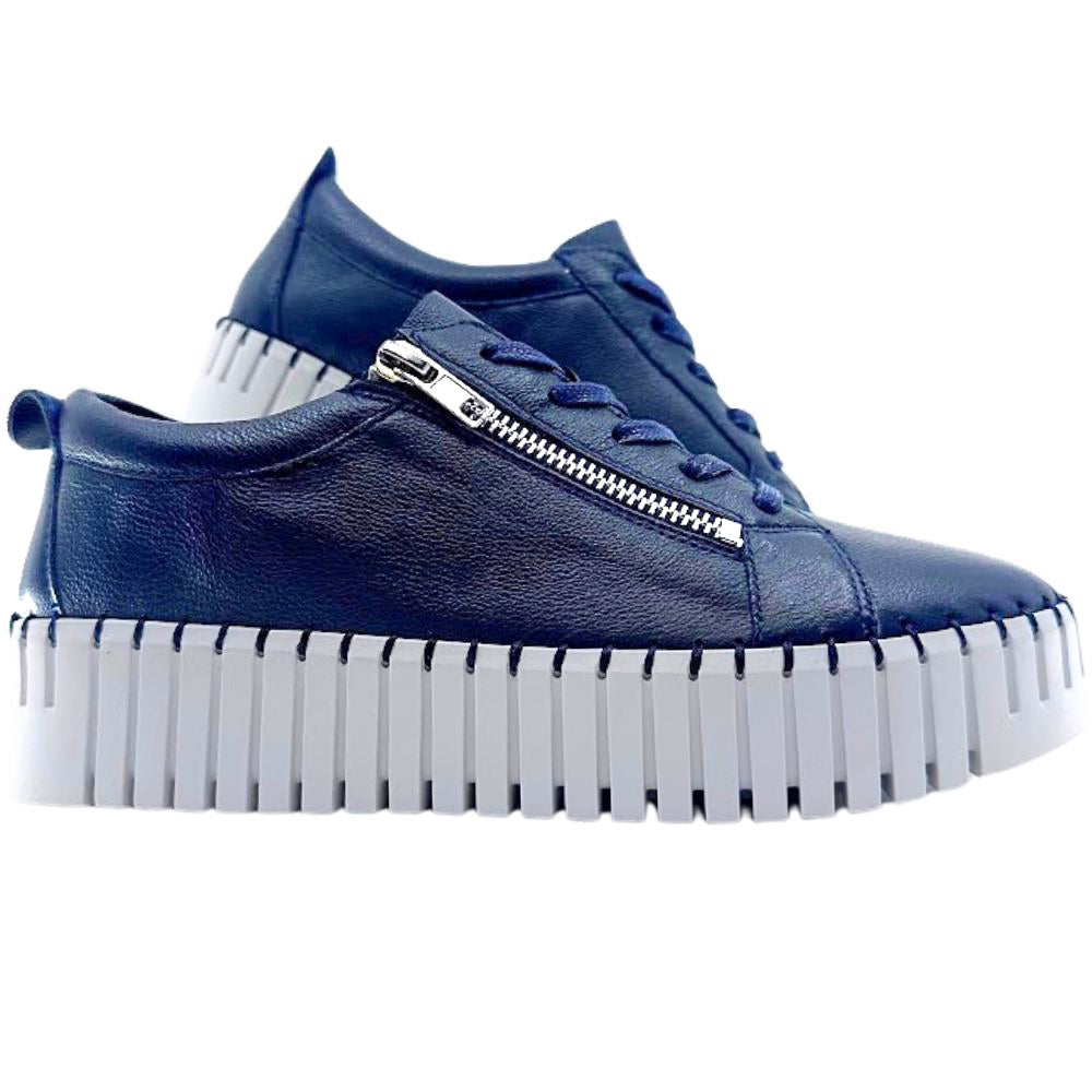 Navy sneakers with a white sole on a white background