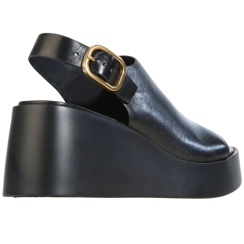 A black leather platform sandal with a chunky platform sole and a wide ankle strap featuring a gold-tone buckle, shown from a side profile view on a white background.