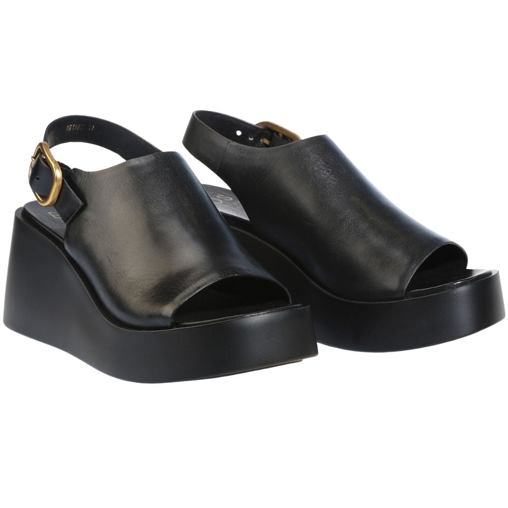 A pair of black leather platform wedge sandals with peep toes, slingback straps, and gold-tone buckle details, shown against a plain white background.