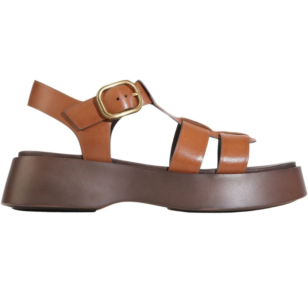 A single platform sandal in tan and dark brown leather with a gold buckle, shown in a side profile on a white background.