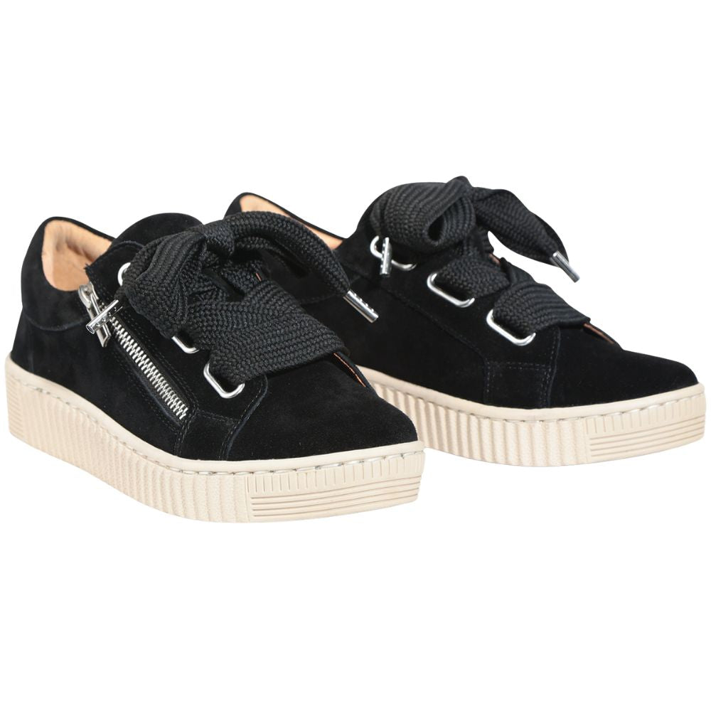 Pair of black suede sneakers with oversized black laces and a zipper on a white background