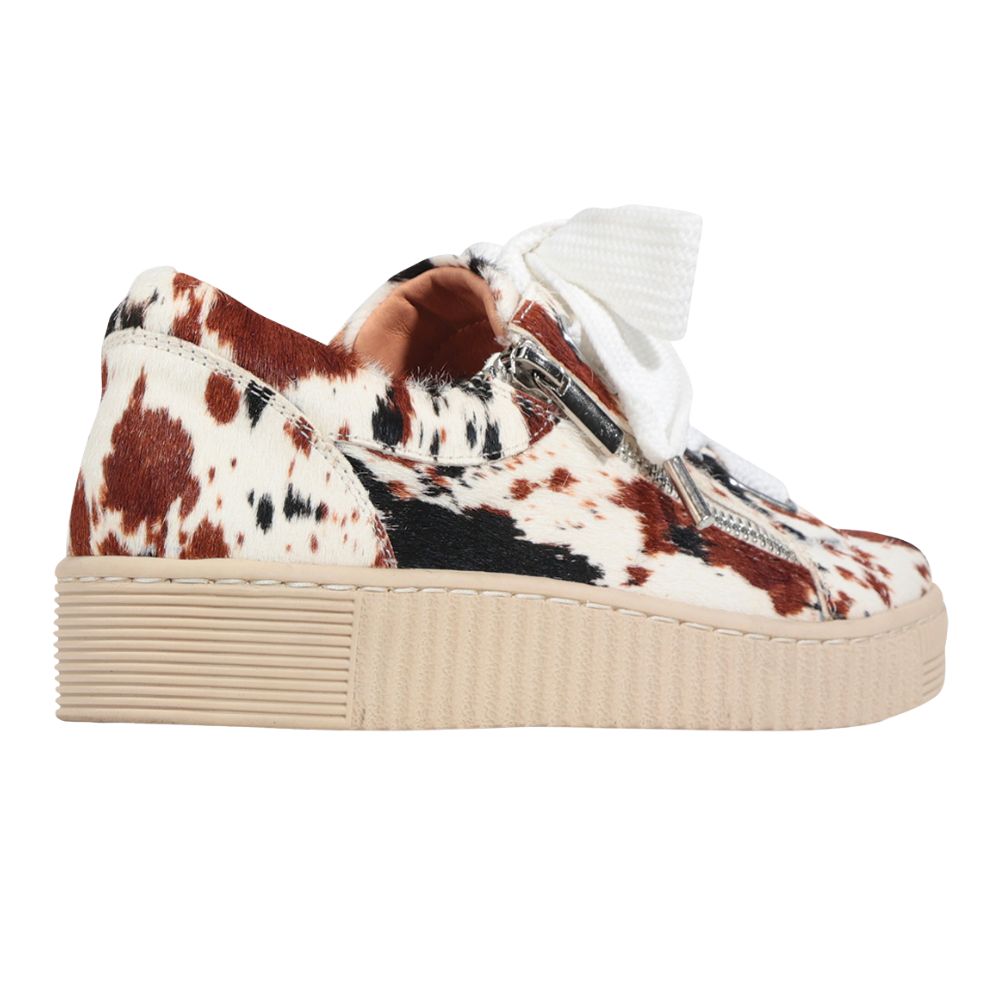 Sneaker with cow print pattern on a white background