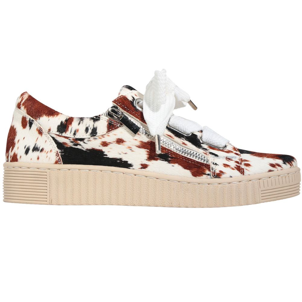 Sneaker with cow print pattern on a white background
