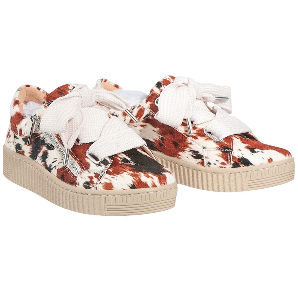 Pair of sneakers with a cow print pattern on a white background