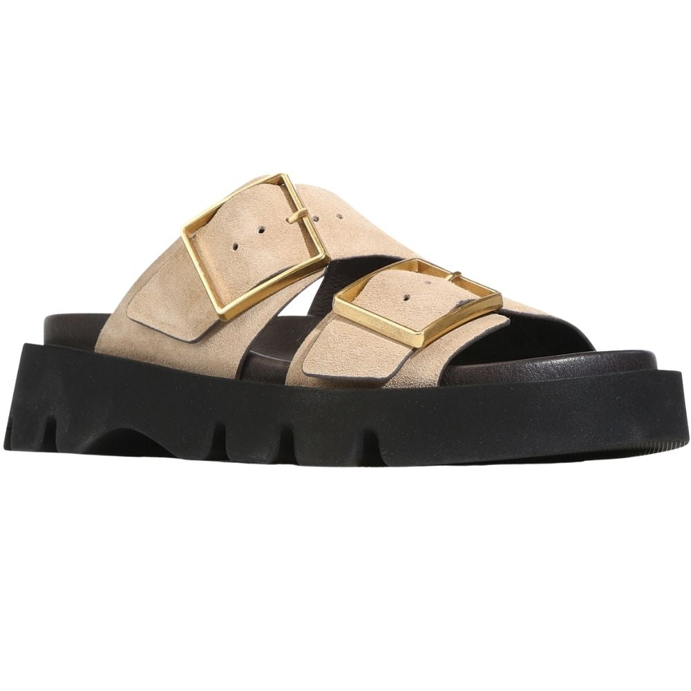 A beige double-strap slide leather sandal with chunky gold-tone buckles and a thick black lug sole, shown in a side profile on a white background.