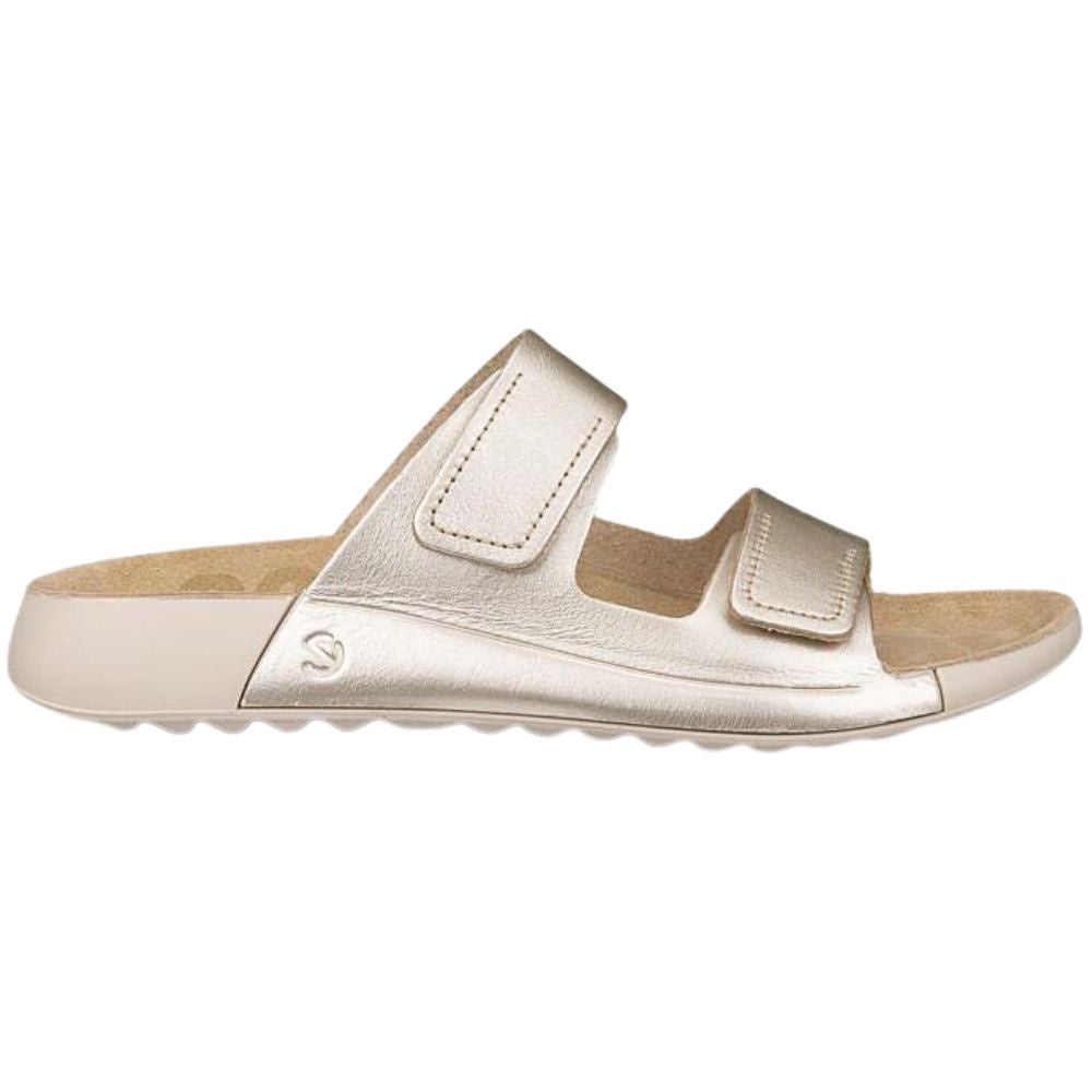 Pale gold sandal with two adjustable straps on a white background