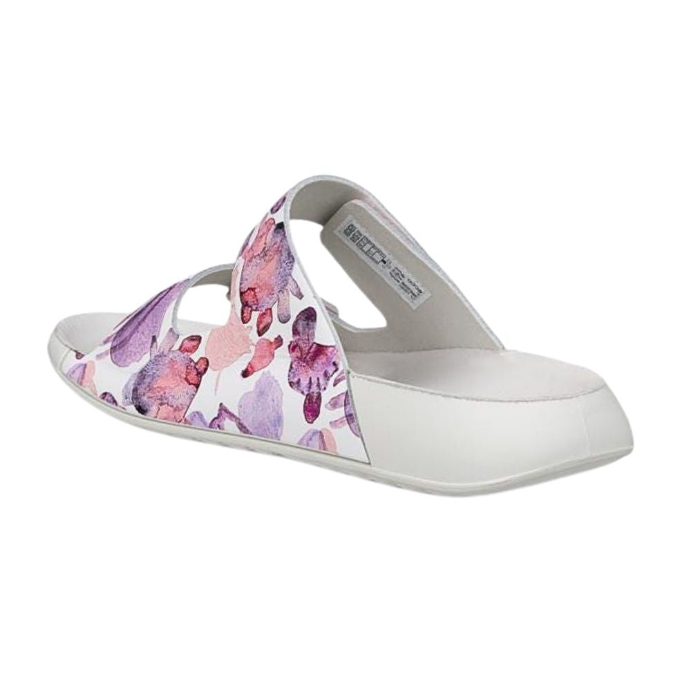 A single white slide sandal with a purple and pink watercolor floral pattern on the upper strap, shown from a side profile on a white background.