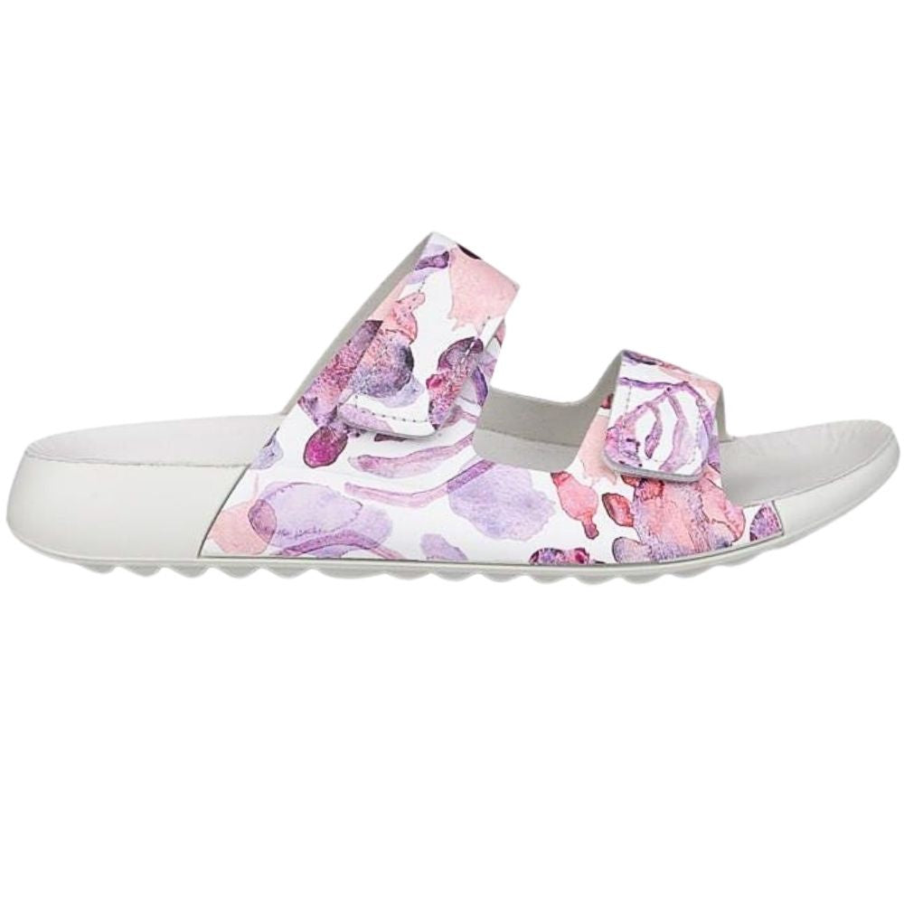 A single women's slide sandal with a white sole and a double-strap upper featuring a pink and purple watercolor floral pattern on a white background.